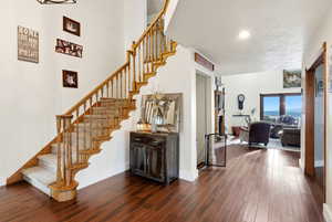 Staircase featuring wood finished floors and recessed lighting
