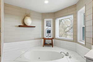 Full bathroom featuring a tub with jets, vanity, and recessed lighting