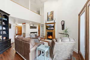 Living area with a fireplace with flush hearth and dark wood-style floors