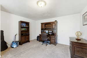 Office with light colored carpet and a textured ceiling