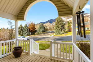 Wooden porch with a mountain view and a lawn