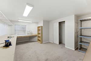 Unfurnished office featuring built in desk and light carpet