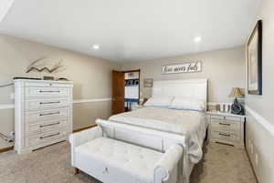 Bedroom featuring wainscoting, light carpet, and recessed lighting