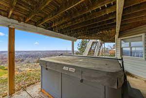 View of patio featuring stairway and a hot tub