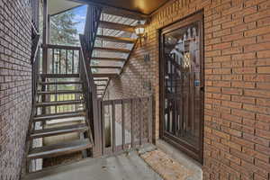 Doorway to property featuring brick siding