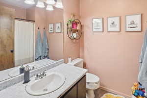 Full bath featuring curtained shower and vanity