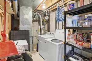 Laundry room featuring heating unit, secured water heater, and washing machine and dryer
