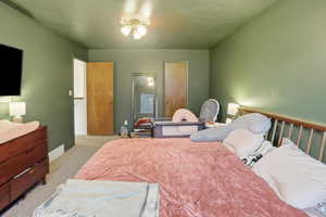 Bedroom featuring light carpet