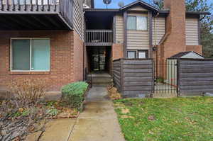 Entrance to property with brick siding, a chimney, and a gate