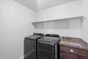 Washroom featuring washer and dryer and baseboards
