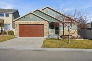 Craftsman inspired home with an attached garage, concrete driveway, and stone siding