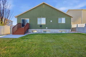 Rear view of house featuring stucco siding and a patio area