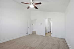 Unfurnished bedroom with light carpet, a ceiling fan, and high vaulted ceiling