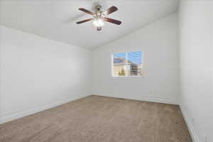 Unfurnished room with light carpet, vaulted ceiling, and ceiling fan