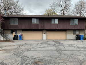 View of front of property featuring an attached garage, driveway, stairs, and brick siding