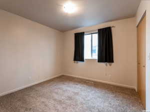 Unfurnished room with carpet flooring and baseboards