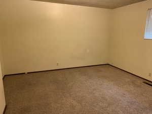 Spare room featuring carpet floors and a textured ceiling