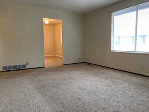 Spare room featuring a textured ceiling and light colored carpet