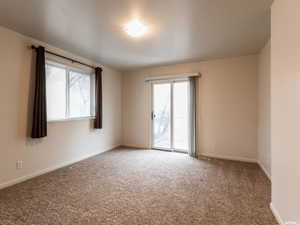 Empty room featuring carpet and baseboards