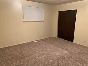 Empty room with carpet floors and a textured ceiling