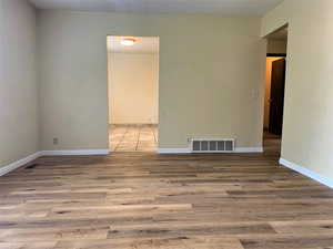 Empty room featuring light wood-style floors and a textured ceiling