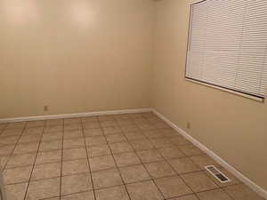 Spare room with light tile patterned flooring and baseboards