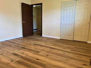 Unfurnished bedroom featuring wood-type flooring and a closet
