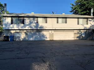 Back of property with stairs and a garage