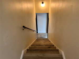 Stairs with wood-type flooring and baseboards