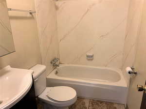 Full bath with vanity, washtub / shower combination, and tile patterned flooring