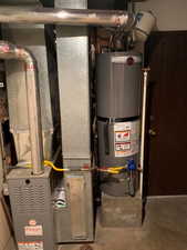 Utility room featuring gas water heater and heating unit