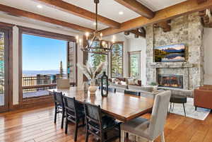Dining area featuring a fireplace, light wood-style floors, a chandelier, a mountain view, and recessed lighting
