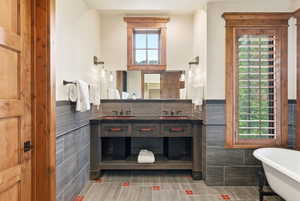 Bathroom featuring a dual vanity with vessel sinks, integrated mirrors, and wall-mounted sconces