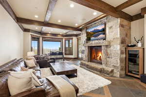 Living room featuring beverage cooler, a fireplace, beamed ceiling, and recessed lighting