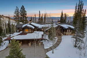 Chalet / cabin with stone siding and a chimney