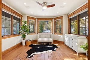 Living area featuring light wood-style flooring, ceiling fan, radiator, and recessed lighting