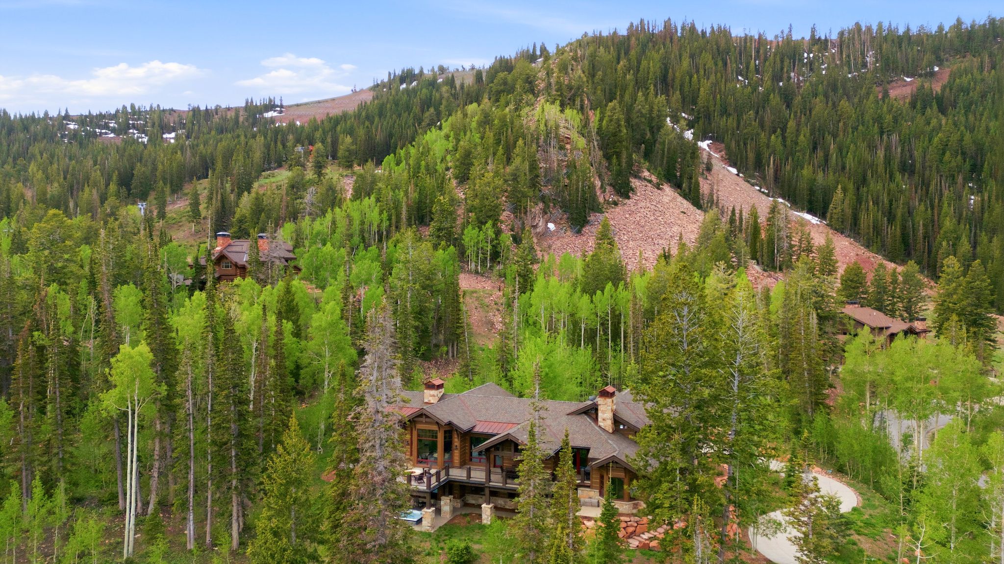 Mountain property nestled among dense evergreen and deciduous trees