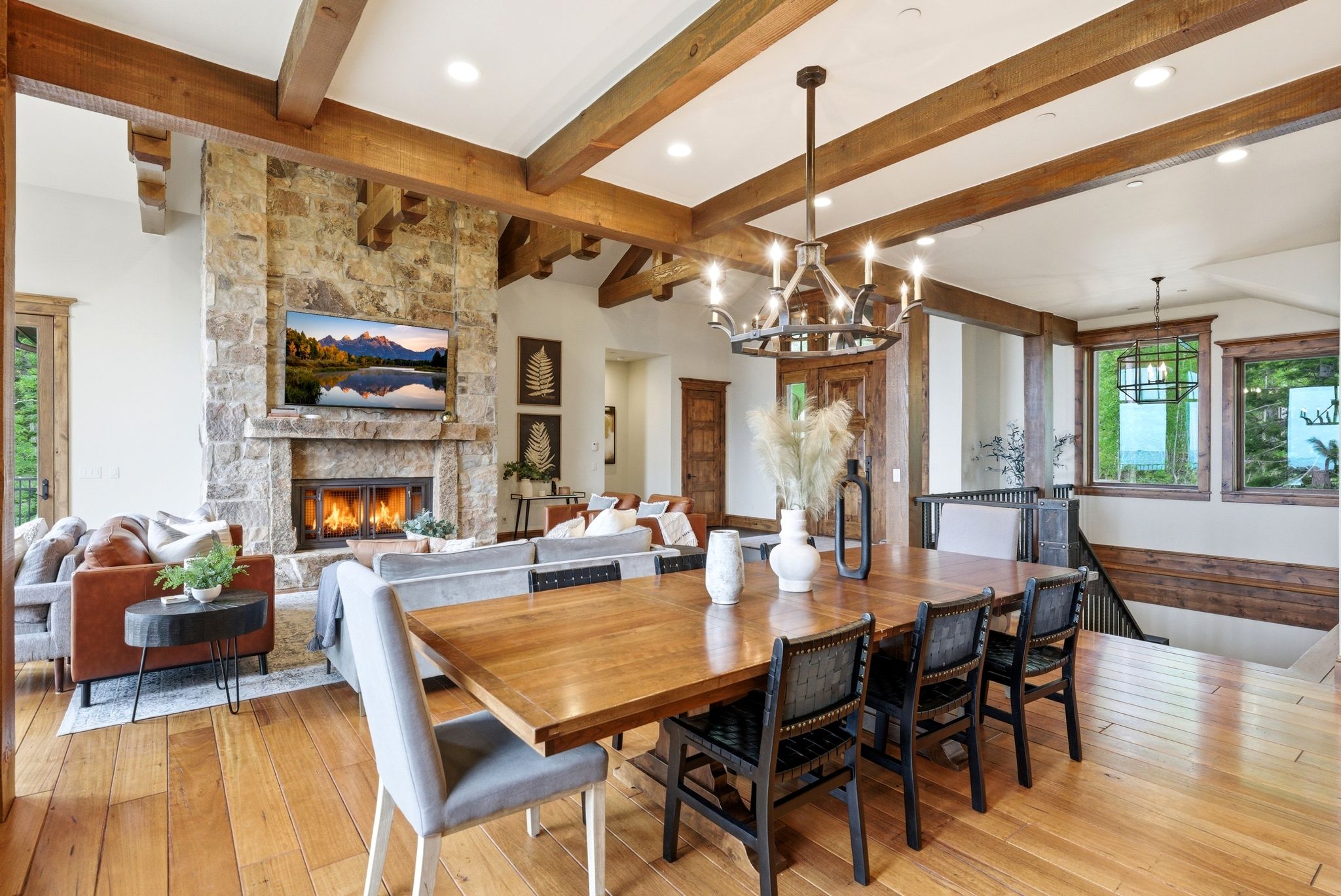 Expansive living area featuring wood-finish flooring and exposed wooden ceiling beams