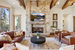 Living area with a fireplace, beamed ceiling, wood finished floors, and recessed lighting