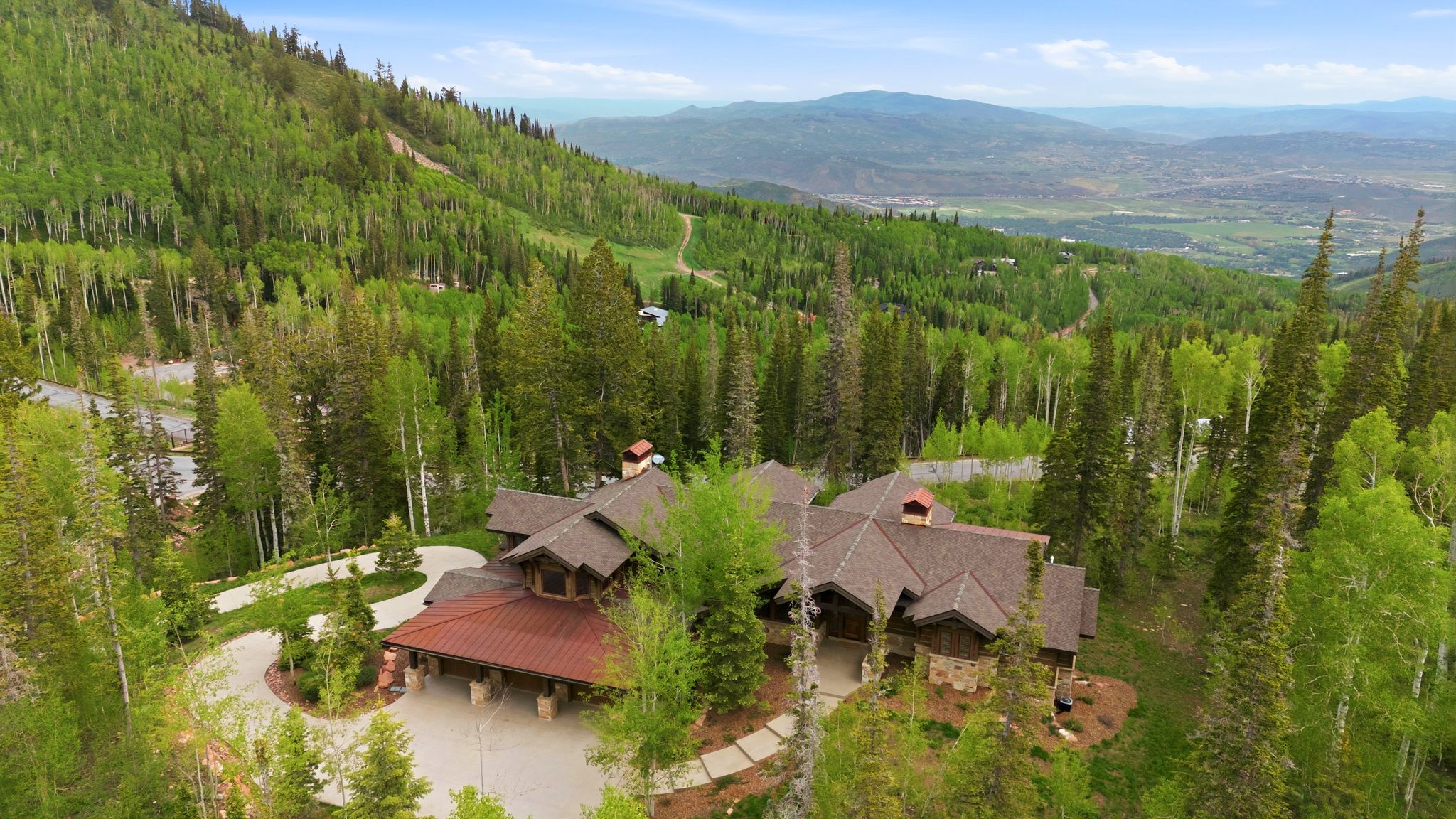 Expansive mountain estate featuring a multi-level architectural design, natural wood siding, and stone accents