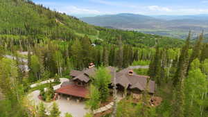 Expansive mountain estate featuring a multi-level architectural design, natural wood siding, and stone accents
