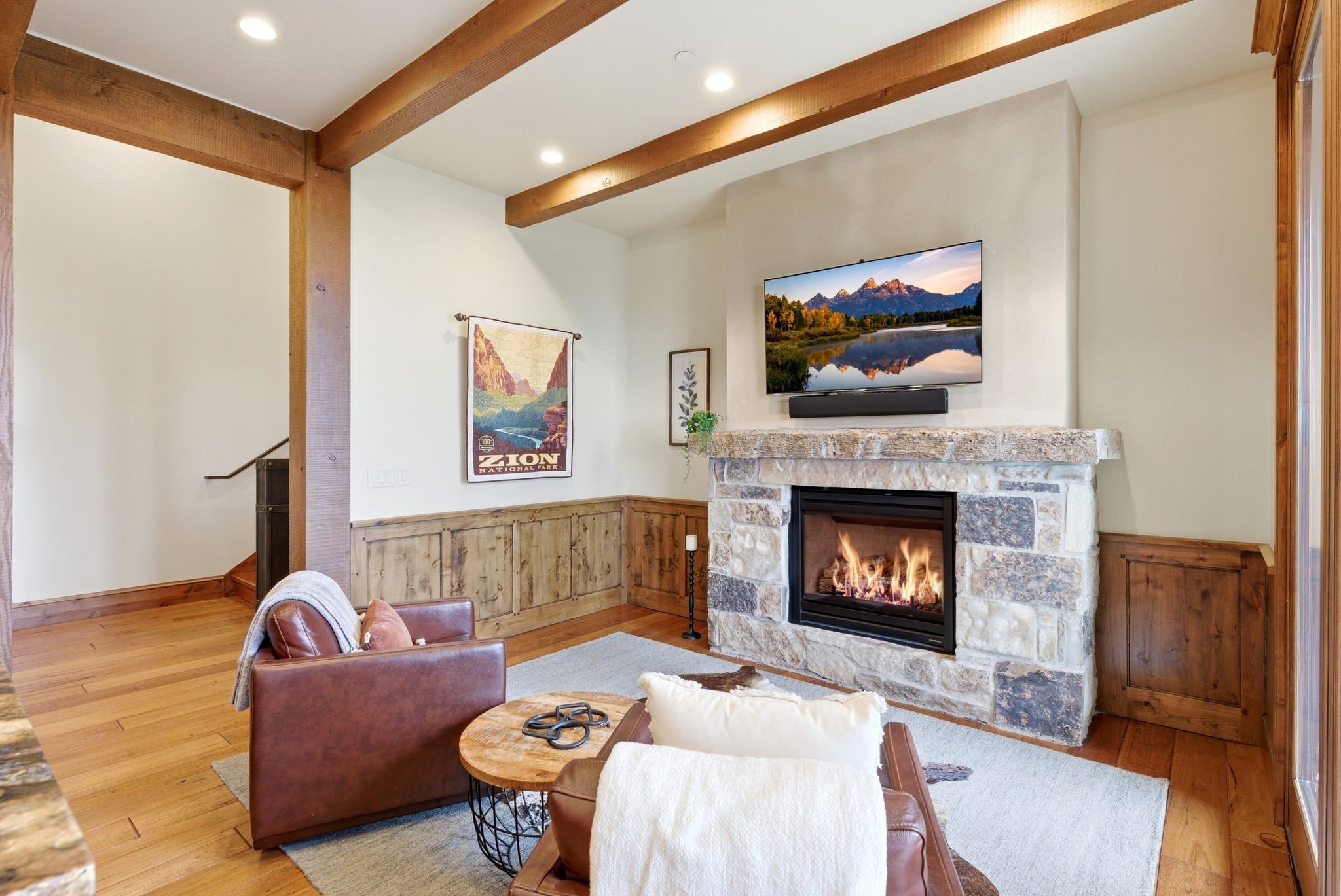 Living area featuring wood-finish flooring, exposed ceiling beams, and recessed lighting