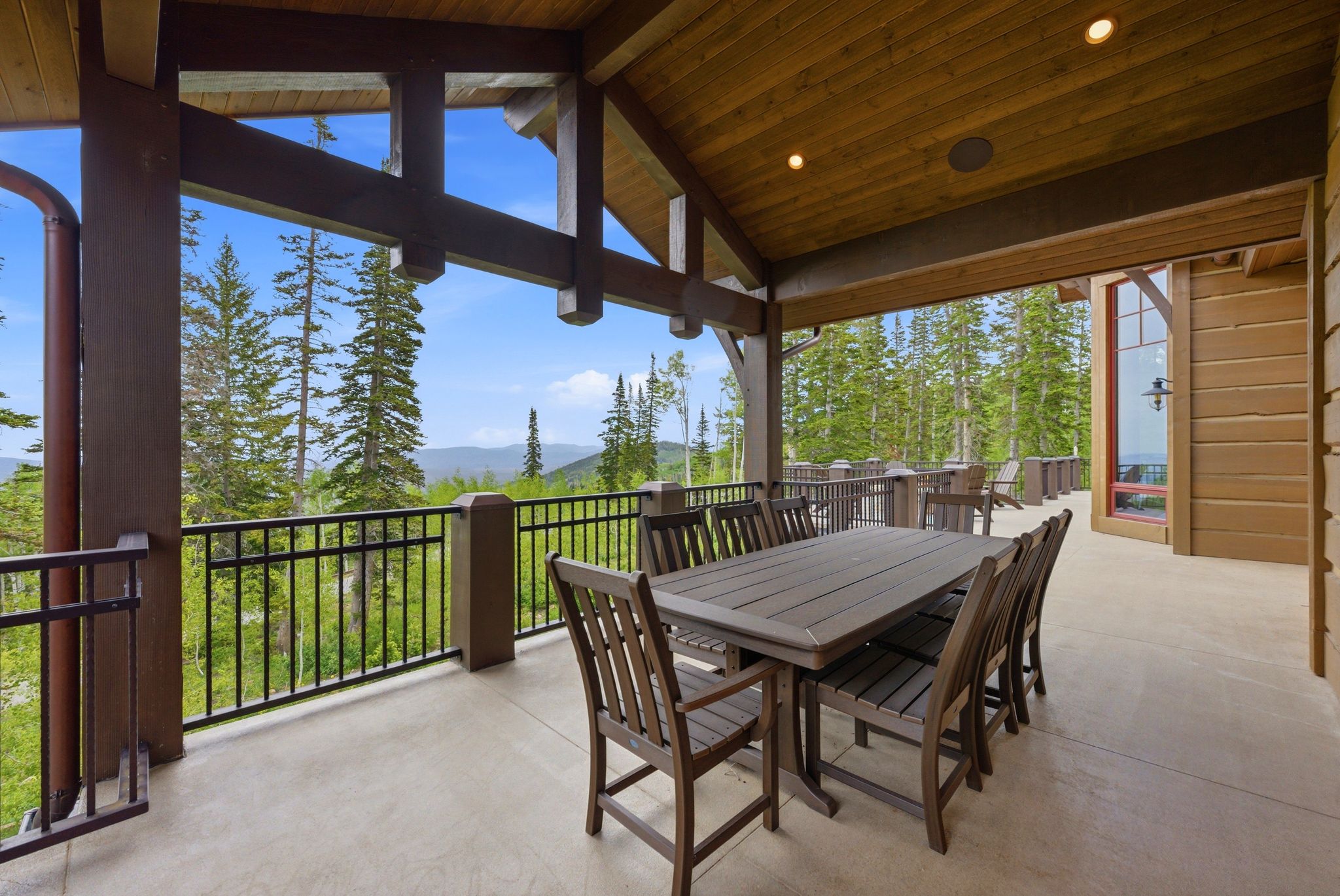 Covered outdoor patio featuring exposed wood beams and a wood-panel ceiling with recessed lighting