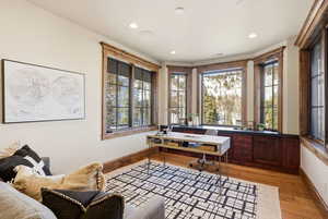 Home office with light wood-type flooring and recessed lighting
