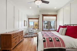 Bedroom with a decorative wall, light wood finished floors, ceiling fan, and recessed lighting