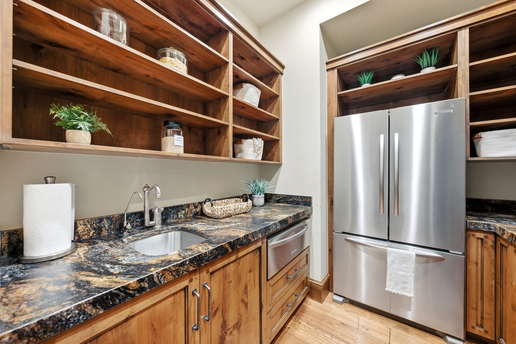 Built-in wood shelving and cabinetry complement the multi-toned countertop