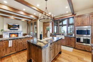 Spacious kitchen featuring wood-finish flooring, exposed ceiling beams, and recessed lighting