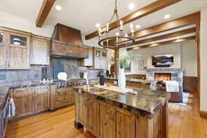 Gourmet kitchen with custom cabinetry, professional-grade range, and a distinctive copper hood