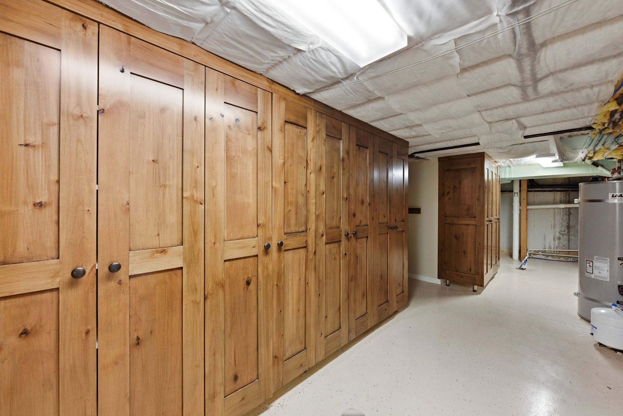 Custom wood-finish cabinetry with dark hardware and a light-toned flooring