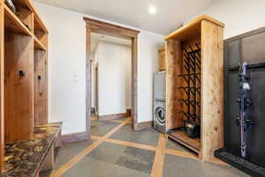 Mudroom featuring stacked washer / dryer and inlaid floor details